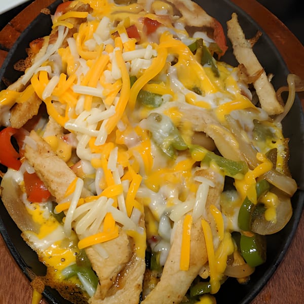 Chicken fajita fries from Galindos Kitchen, topped with melted cheese, peppers, and onions.
